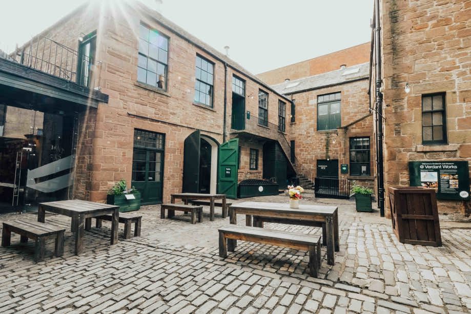 Verdant Works courtyard with picnic benches and green doors